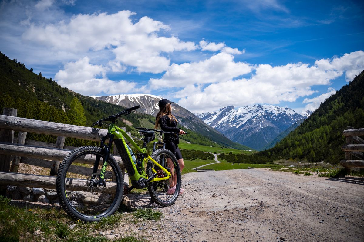 Ciclista in e-bike su una strada di montagna panoramica